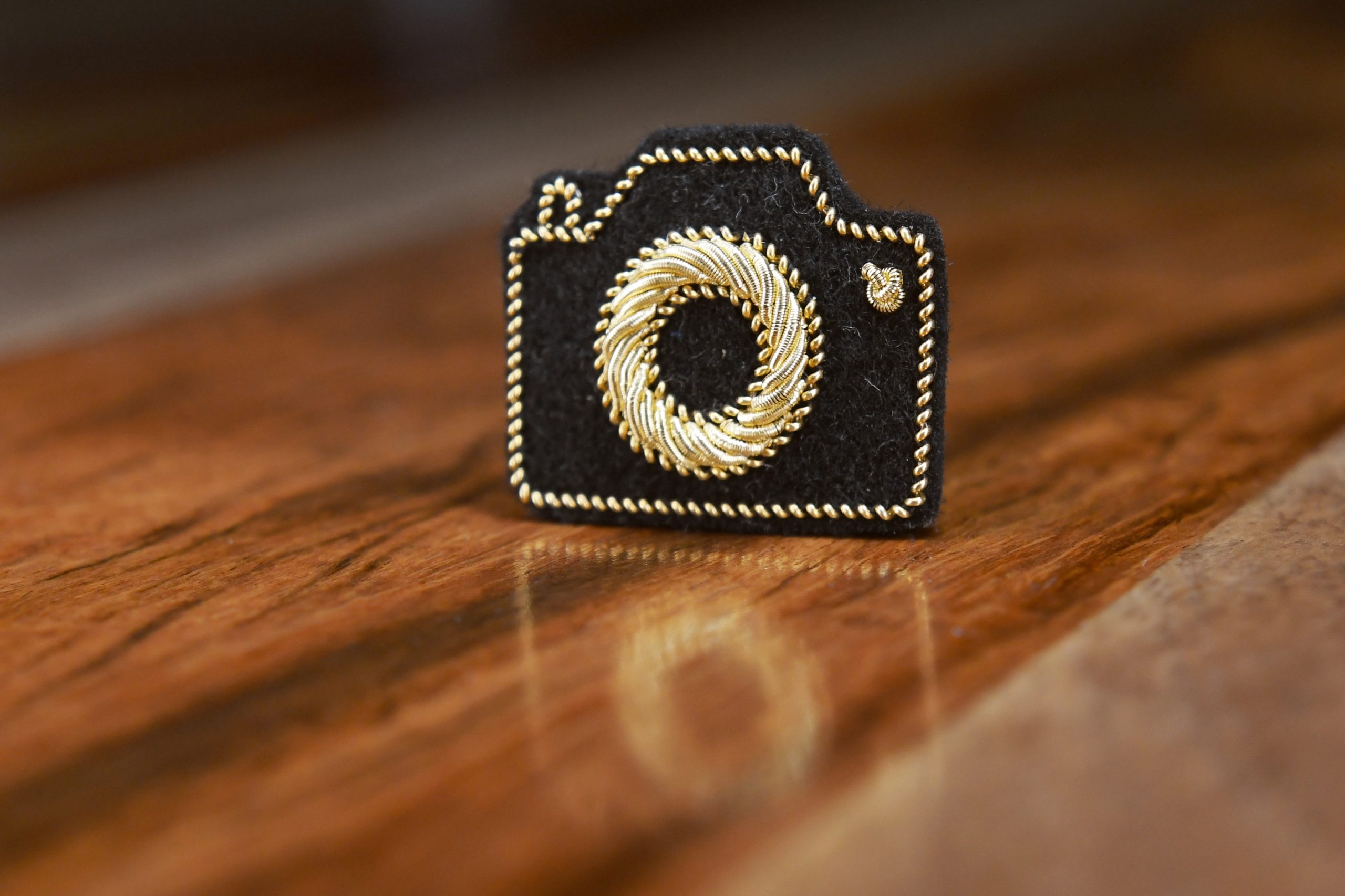 Pin's appareil photo (or, fond noir).