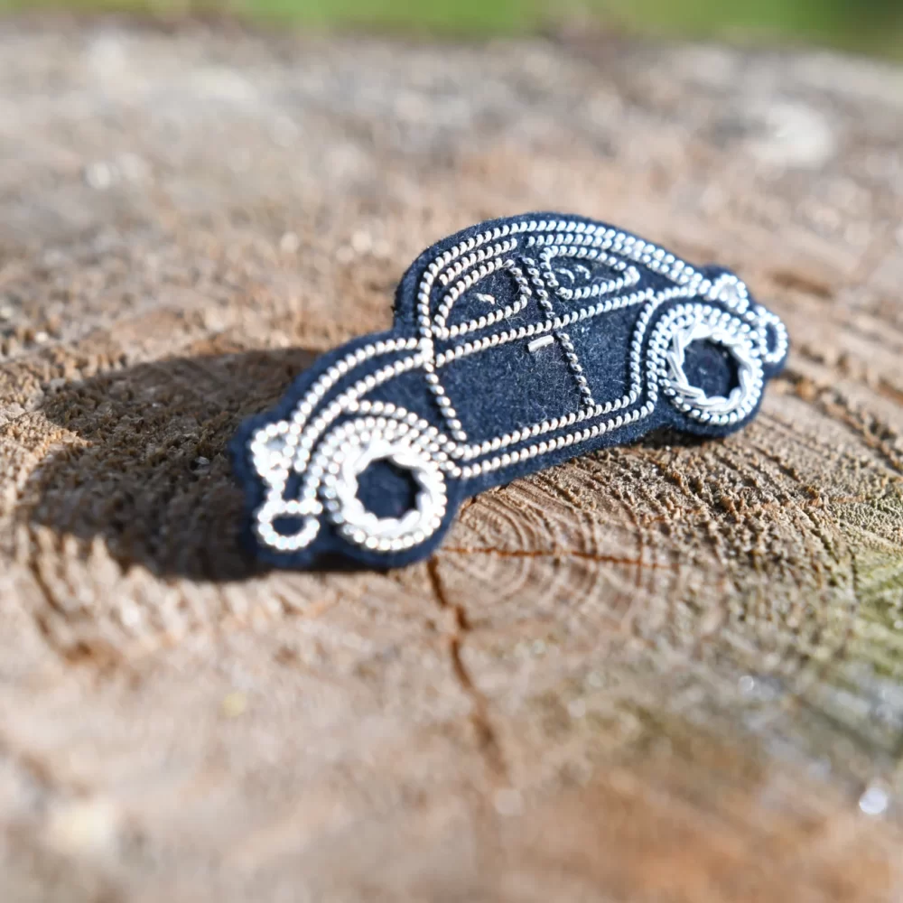 Pin's coccinelle (argent, fond bleu gris)