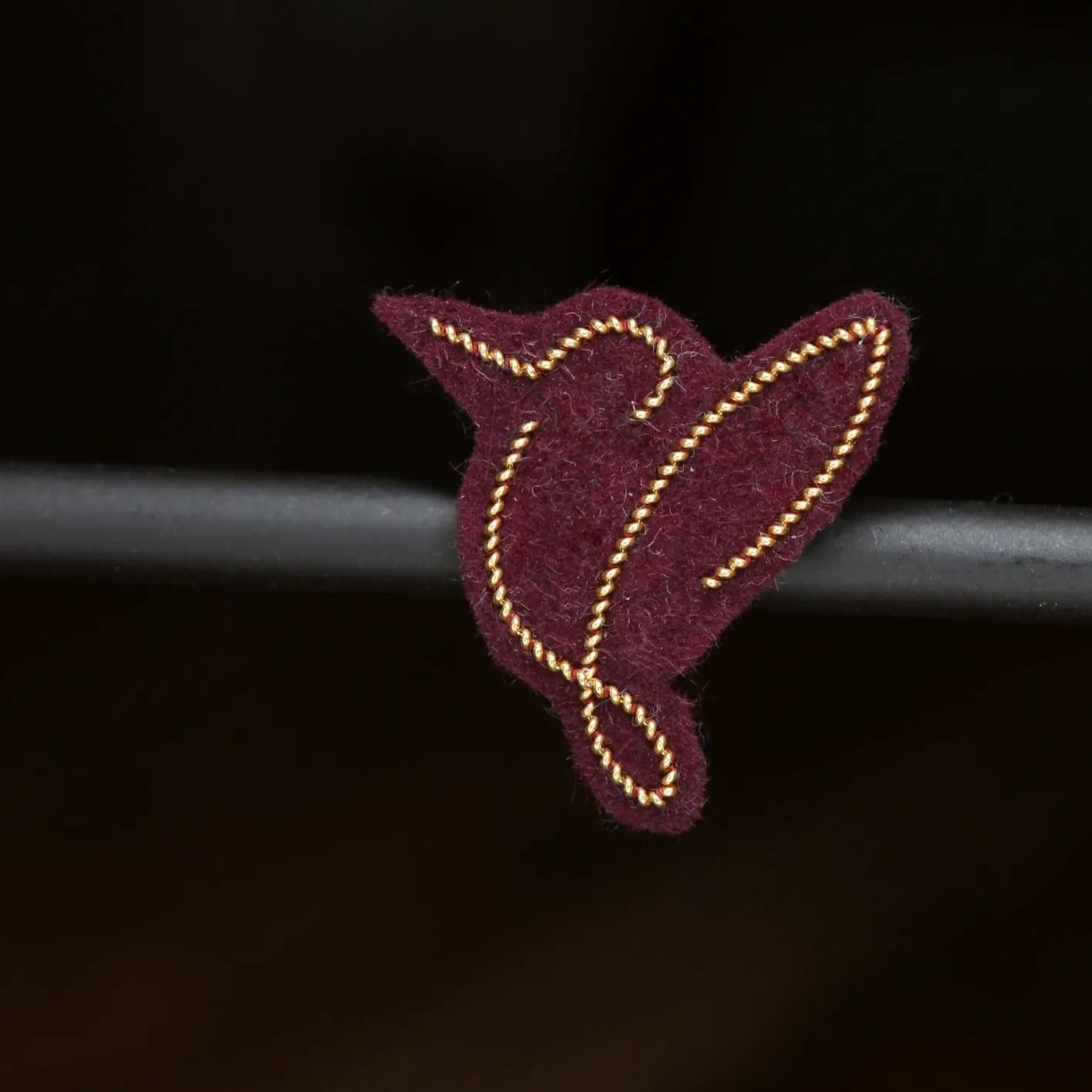 Pin's oiseau (or, fond bordeaux)